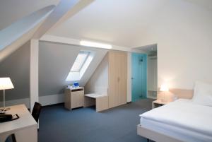 乌斯特Hotel Ochsen的配有一张床、一张书桌和一扇窗户的酒店客房