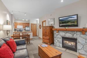 惠斯勒Lost Lake Lodge by Whistler Premier的客厅设有壁炉,上面配有电视