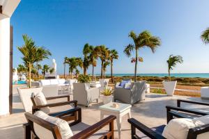 圣玛丽亚Hotel LIVVO Budha Beach的一个带桌椅的庭院和海滩