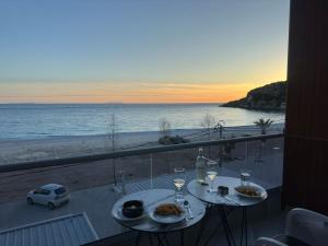希马拉Anxhelos Hotel的一张带食物的桌子,享有海滩美景