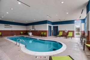斯蒂尔沃特SpringHill Suites by Marriott Stillwater的医院里的一个游泳池,配有椅子和桌子