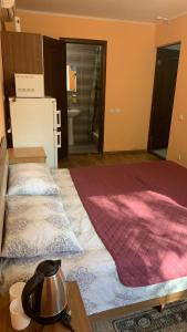 OrlovshchinaБаза відпочинку «Павлоградець»的客房设有一张大床和一台冰箱。