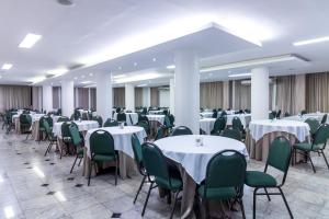 戈亚尼亚Umuarama Plaza Hotel by Castelo Itaipava的宴会厅配有白色桌子和绿色椅子