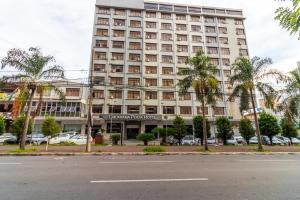 戈亚尼亚Umuarama Plaza Hotel by Castelo Itaipava的一座棕榈树环绕的大建筑
