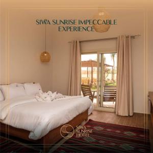 锡瓦Siwa Sunrise Hotel的卧室配有带白色棉被的床