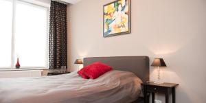 布鲁日布鲁日住宿加早餐酒店的一间卧室配有一张红色枕头的床