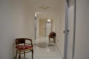 Casa FrancesiPark Hotel的走廊上设有两把椅子,走廊上设有门