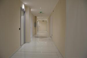 Casa FrancesiPark Hotel的走廊设有白色墙壁和白色瓷砖地板