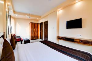 kolkataEco Corporate Inn 2 Rajarhat的配有一张床和一台平面电视的酒店客房