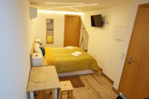 塞亚CASA ORIGENS ll的一间小卧室,配有一张黄色的床和一张桌子