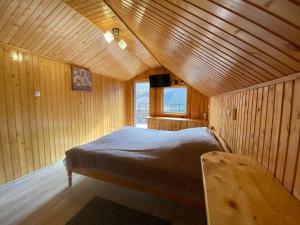 亚列姆切Акорди Плеса的木制客房内的一间卧室,配有一张床