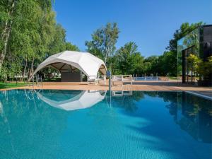 加茨比亚格拉Rosevia Resort & Spa的一座游泳池,在一座建筑旁边设有帐篷