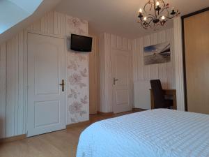 ArdevonB&B La Rive - Le Mont Saint Michel的卧室配有一张床,墙上配有电视。