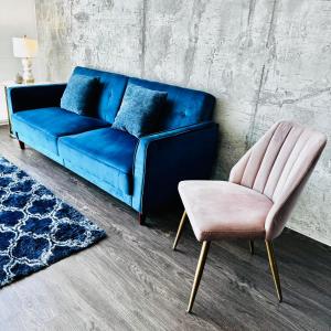 洛杉矶Hollywood Luxury Stay & FREE PARKING的客厅里设有蓝色的沙发和粉红色的椅子
