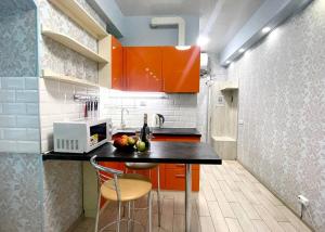 哈尔科夫NewStyle的厨房配有橙色橱柜和黑色台面