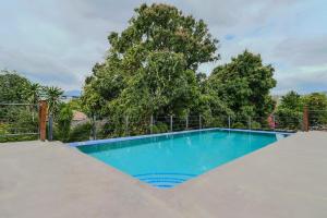 金斯敦Luxury DreamCondo Bromptons的一个带栅栏和树木的蓝色游泳池