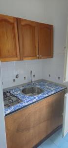 普罗奇达Piccolo Tirreno Hotel Residence的厨房柜台设有水槽和炉灶。