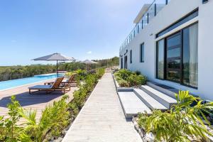 Long Bay HillsOnyx I Long Bay Retreat I Luxury Stay Near Grace Bay & Long Bay Beach的一座带长椅和游泳池的建筑