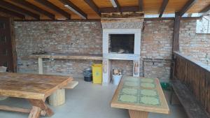 古拉哈莫卢洛伊Casa Irimescu的室外厨房配有木桌和砖墙
