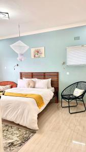 MzuzuChaya accommodation B&B and self catering的一间卧室配有一张大床和一把椅子