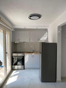 卡瓦拉White Apartment的厨房配有黑色冰箱和水槽
