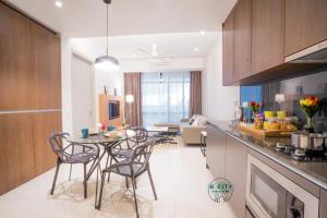 努沙再也Grand Medini Suites by JBcity Home的厨房以及带桌椅的起居室。
