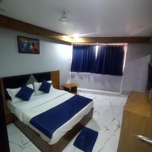 艾哈迈达巴德HOTEL SHREE RADHE的一间卧室配有一张带蓝色床单的床和一扇窗户。