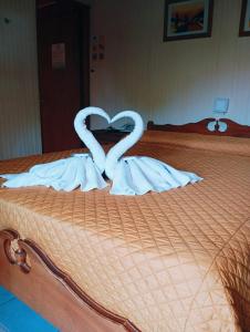 特玛斯德戴曼Apart Hotel Géminis的两个天鹅在床上心跳