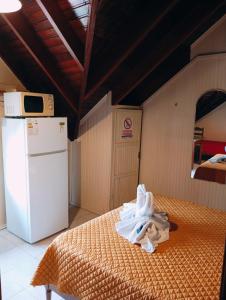 特玛斯德戴曼Apart Hotel Géminis的客房设有床、冰箱和冰箱。
