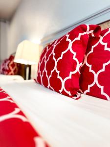 肖尔莱恩Americas Inn & Suite的一张带红色和白色枕头的床