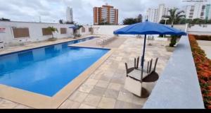 圣路易斯Belíssimo apartamento a 01 km da litorânea的一个带蓝伞和椅子的游泳池
