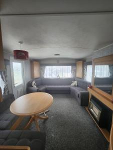 英戈尔德梅尔斯Kingfisher OAK 1098 Dees Caravan Lettings的客厅配有沙发和桌子