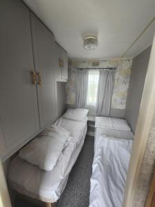 英戈尔德梅尔斯Kingfisher OAK 1098 Dees Caravan Lettings的小房间设有两张床和窗户
