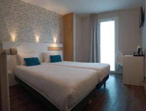 波尔尼克阿利泽布里特酒店的卧室配有带蓝色枕头的大型白色床