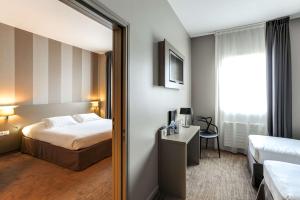比尼克Brit Hotel Le Galion & Spa的酒店客房,配有床和镜子
