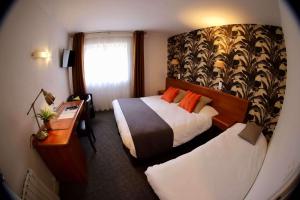圣伊莱尔迪阿尔库厄Brit Hotel le Cygne的酒店客房配有两张床和一张书桌
