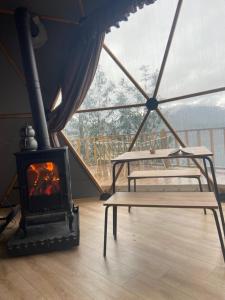 贾马里海姆森Bogina Dome & Suite - Çamlıhemşin的帐篷内的壁炉,配有两张床和一张桌子