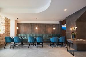 瓦尔纳Bizarre Boutique Hotel的一间设有蓝色椅子的用餐室和一间酒吧