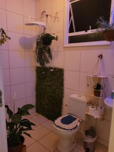 里贝朗普雷托Casa com piscina aconchegante的一间带卫生间、窗户和植物的浴室