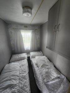 英戈尔德梅尔斯Kingfisher OAK 1098 Dees Caravan Lettings的小房间设有两张床和窗户