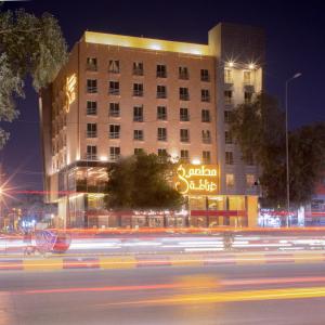 纳杰夫Granada Hotel的一座建筑物,晚上在建筑物的一侧有标志