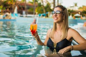 林斯Blue Tree Thermas de Lins Resort的女人在游泳池里喝一杯