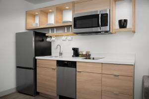 伯明翰TownePlace Suites by Marriott Birmingham South的厨房配有黑色冰箱和微波炉。