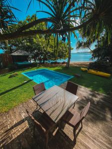 Tohautu米提拉帕别墅酒店的游泳池旁的野餐桌椅