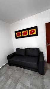 科尔多瓦Apartamento poeta lugones的墙上有两张照片的房间的一张黑色沙发