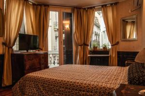 布宜诺斯艾利斯DEL900 Hotel Boutique的一间卧室设有一张床、一台电视和一个窗口。