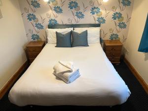 葛特纳格林Hazeldene Hotel的一间卧室配有一张大床和毛巾