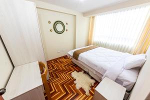 库斯科INYAWASI APARTMENT的一间卧室设有床、窗户和地毯。
