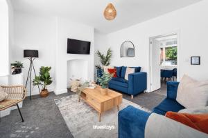 EtruriaNEW Stanley House - Stunning 2 Bedroom House的客厅配有蓝色的沙发和桌子