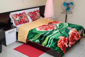 利隆圭Moments Lodge的一间卧室配有一张带绿色和红色毯子的床